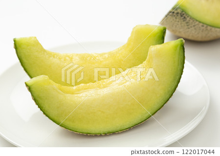 Muskmelon on a plate on a white background Muskmelon on a plate on a white background 122017044