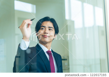 年輕商人用筆在玻璃上寫圖表 122017193