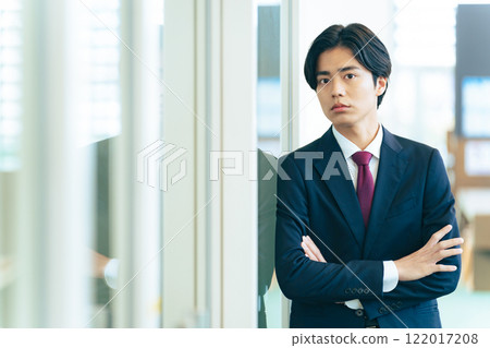 站立在辦公室的年輕商人 站立在辦公室的年輕商人 122017208