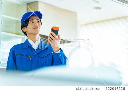 A worker measuring the indoor environment with a portable measuring instrument A worker measuring the indoor environment with a portable measuring instrument 122017226