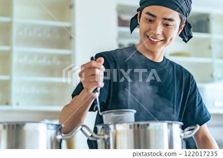 餐廳服務員在廚房煮麵條 餐廳服務員在廚房煮麵條 122017235