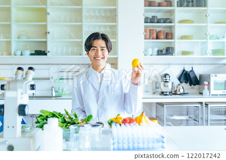 展示蔬菜和水果的男性研究員,註冊營養師 展示蔬菜和水果的男性研究員,註冊營養師 122017242