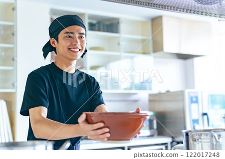 A ramen shop clerk offering a bowl of rice 122017248