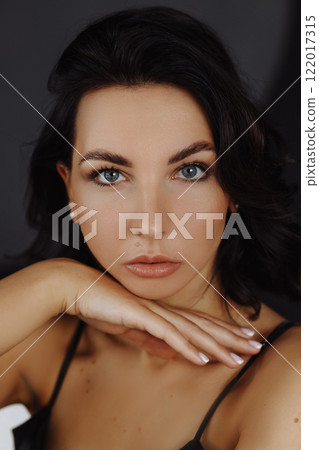 Portrait caucasian woman in green dress posing on white background touching face. Front view. Portrait caucasian woman in green dress posing on white background touching face. Front view. 122017315