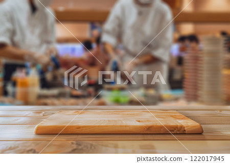Wooden table with pedestal in blur Professional Sushi Chefs Preparing Fresh Dishes in a Restaurant Kitchen 122017945