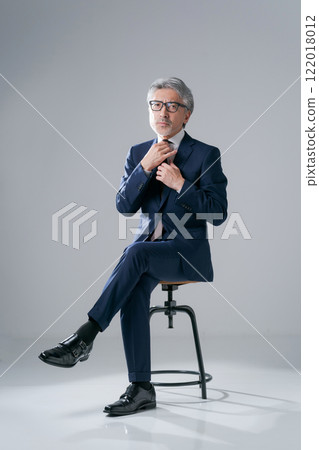 man in suit sitting on chair 122018012