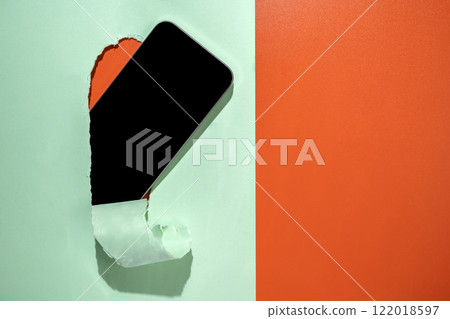 Blank mobile phone from the hole of ripped paper. Mockup or Copy space. Template. Concept of technology or communication Blank mobile phone from the hole of ripped paper. Mockup or Copy space. Template. Concept of technology or communication 122018597