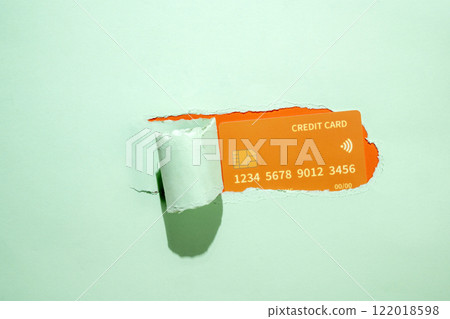 Credit card from the hole of ripped paper. Mockup or Copy space. Concept of business, earning, money, or banking 122018598