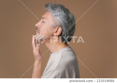 Senior men placing hands on their jaws 122019088