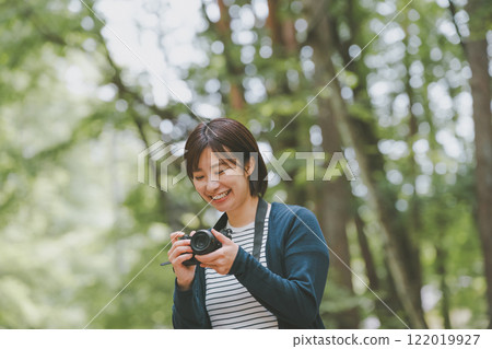 A woman with a single lens reflex camera 122019927