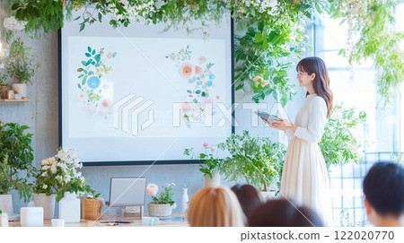 Young woman giving a presentation indoors with plenty of natural light - Natural 122020770