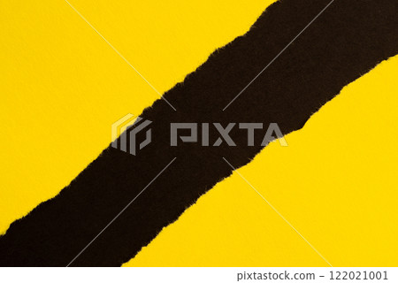 Torn yellow paper on black background Torn yellow paper on black background 122021001