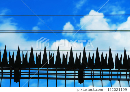 Stainless steel amulet (shinobi-gaeshi) on a railroad fence and blue sky Stainless steel amulet (shinobi-gaeshi) on a railroad fence and blue sky 122021199