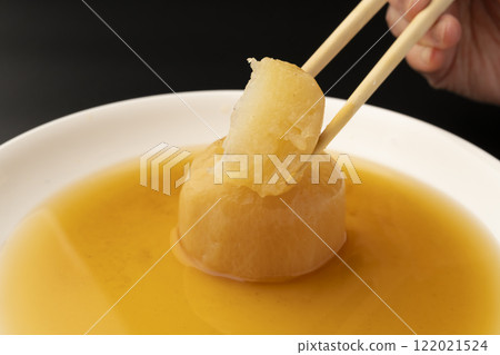 Lifting boiled radish with chopsticks Lifting boiled radish with chopsticks 122021524