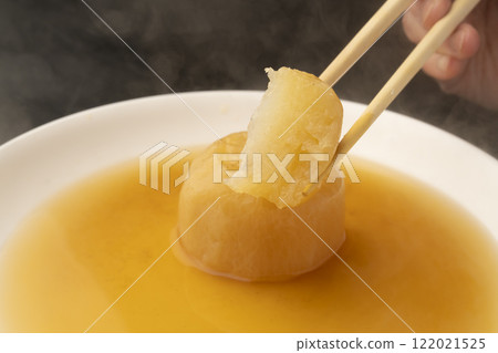 Lifting boiled radish with chopsticks Lifting boiled radish with chopsticks 122021525