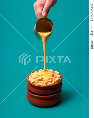 Mac and cheese with melted cheddar cheese, isolated on a blue background 122022005