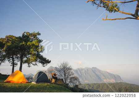 landscape and travel concept with asian man relax see sunset camping tent on mountain landscape and travel concept with asian man relax see sunset camping tent on mountain 122022058