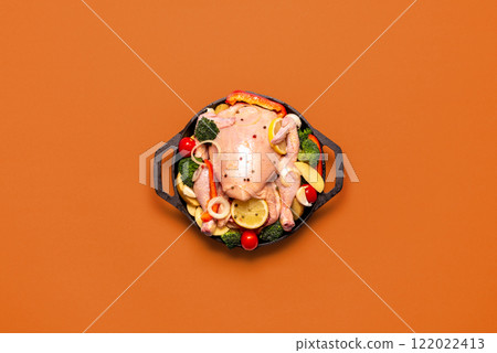 Raw chicken with vegetables, ready to be cooked, in an iron cast, top view Raw chicken with vegetables, ready to be cooked, in an iron cast, top view 122022413