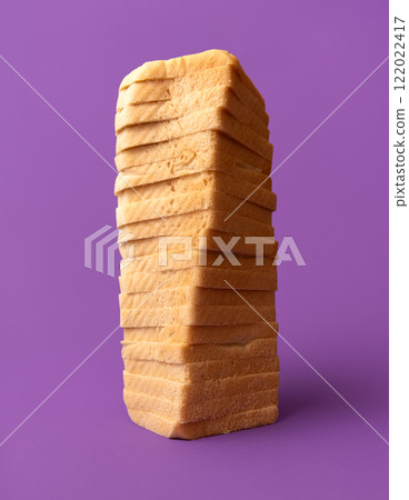 Soft toast bread, slices stacked on a purple table, low-angle view 122022417