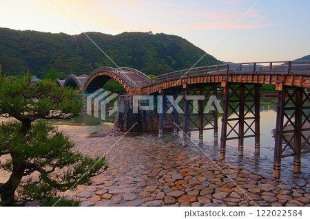 A view of the Kintai Bridge with the thin clouds of the May evening sky and Iwakuni Castle in the background. 122022584