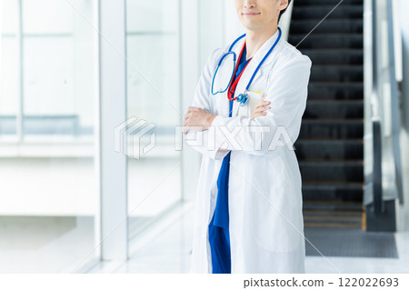 A man in a white coat working in a medical facility 122022693