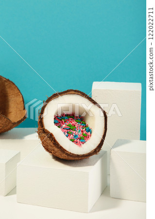 Coconut on a blue background. Half of coconut with sprinkles. Top view. 122022711