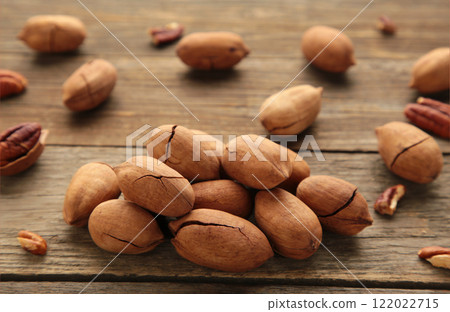 Pecan nuts on a brown wooden table. Pecan nuts on a brown wooden table. 122022715