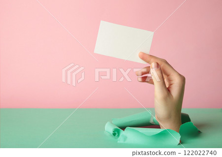 Female holding a credit card break through the paper 122022740