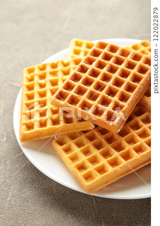 Belgian waffles. Belgian waffles on white plate on grey background. Freshly baked Belgian waffles. Belgian waffles. Belgian waffles on white plate on grey background. Freshly baked Belgian waffles. 122022879