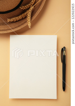 White invitation card mockup with a lagurus on a beige table. White sheet with hat and pen 122022915