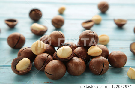 Peeled macadamia nuts. Horizontal composition on blue background. 122022974