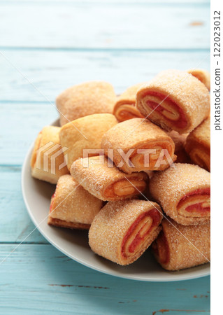 Homemade cookies, mini rolls with apricot jam on blue background. Top view Homemade cookies, mini rolls with apricot jam on blue background. Top view 122023012