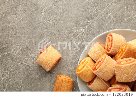 Homemade cookies, mini rolls with apricot jam in plate on grey background. Top view Homemade cookies, mini rolls with apricot jam in plate on grey background. Top view 122023019