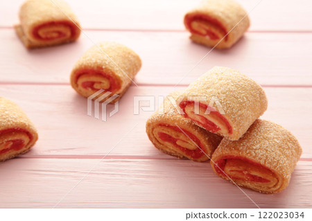 Homemade cookies, mini rolls with apricot jam on pink background. Top view Homemade cookies, mini rolls with apricot jam on pink background. Top view 122023034