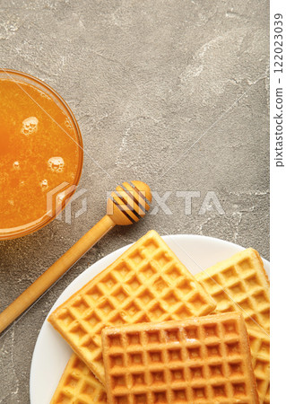 Belgian waffles on white platewith honey. Vertical photo. 122023039