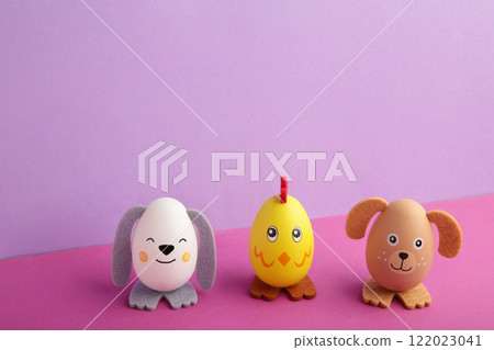 Easter holiday concept with cute handmade eggs, dogs, chicks and cat on purple background. 122023041