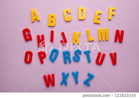 Magnetic plastic alphabet letters on purple background. 122023310