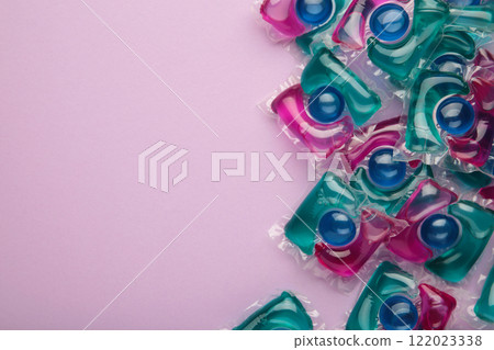 Laundry capsule detergent pods for washing clothes on purple background. Laundry capsule detergent pods for washing clothes on purple background. 122023338
