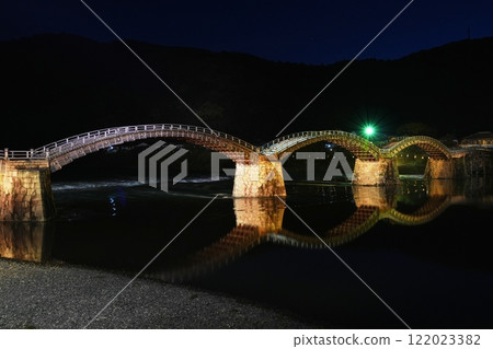 Kintai Bridge shining with light up against the blue hour sky and pitch black mountains in the background Ver4 122023382
