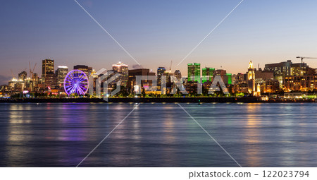 Old Port of Montreal and downtown skyline at night. Colorful buildings lights reflected in water. Montreal city, Quebec, Canada. 122023794
