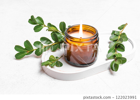 Burning soy wax candle and green leaves Burning soy wax candle and green leaves 122023991