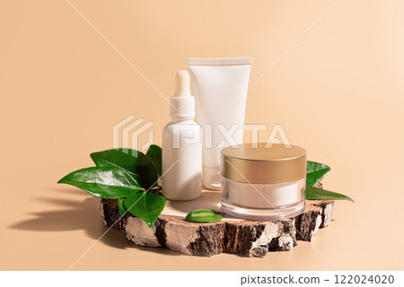 Beauty products packaging with green leaves on wooden cut 122024020
