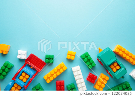 Multicolored blocks of the children's constructor lie on blue background. 122024085