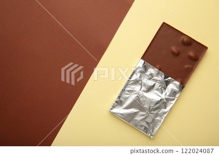 Chocolate wrapped in foil, clipping path on brown background. 122024087