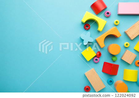 Multicolored blocks of the children's constructor lie on blue background. Space for text Multicolored blocks of the children's constructor lie on blue background. Space for text 122024092
