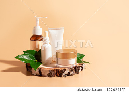 Cosmetic beauty products on wooden cut with green leaves 122024151