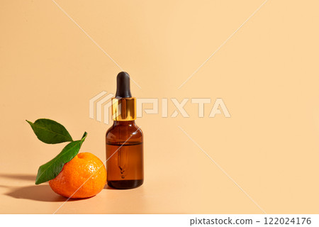 Face serum, essential oil bottle and orange fruit 122024176