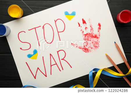 Inscription Stop war with baby handprint on black background, conflict between Ukraine and Russia. No war, stop war, russian aggression. Ukrainian patriot. 122024286