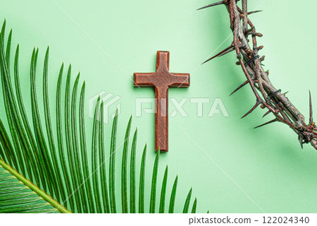 Palm Sunday. Thorn crown, wooden cross and palm leaf Palm Sunday. Thorn crown, wooden cross and palm leaf 122024340