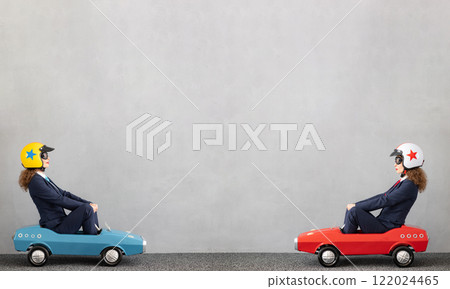 Successfull businesswomen driving toy car outdoor 122024465